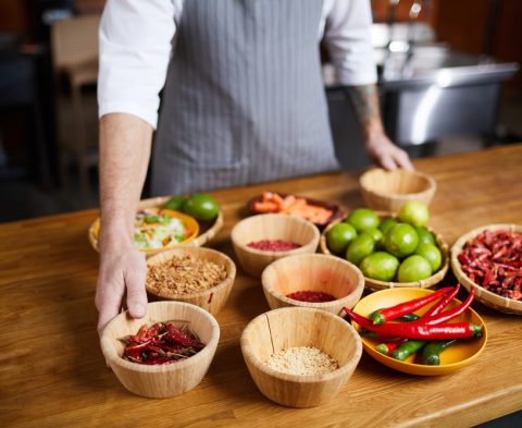 Mid section portrait of professional chef choosing aromatic spices while cooking in restaurant kitchen, copy space